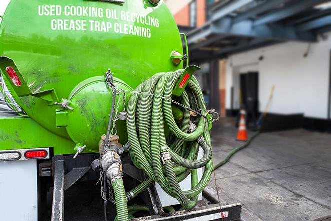 a vacuum truck pumping out a large underground grease trap in Arlington